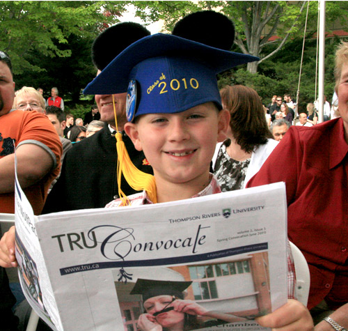 Young attendee of Thompson Rivers University Convocation reads the TRU Convocate