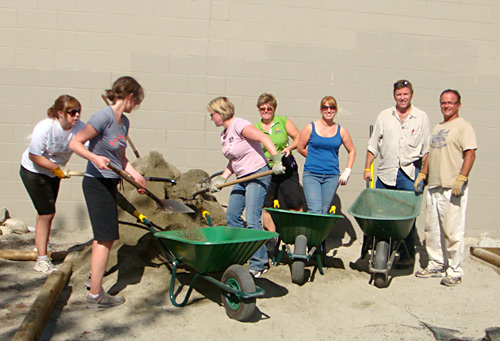 Filling wheelbarrows full of gravel for pathways at the Kamloops Boys and Girls Club.