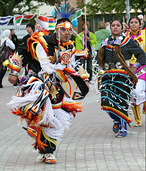 First Nations dancers in traditional regalia lead the international flag parade. Following the parade was an unveiling and raising of a flag recognizing and honouring Secwepemc First Nations bands. TRU is located in the heart of Secwepemc territory and the flag (see below) is one more visual reminder of TRU’s mandate to Indigenize the campus. 