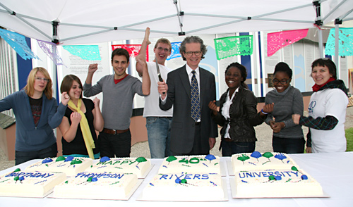 Those cutting the TRU 40th birthday cake give an enthusiastic cheer.  