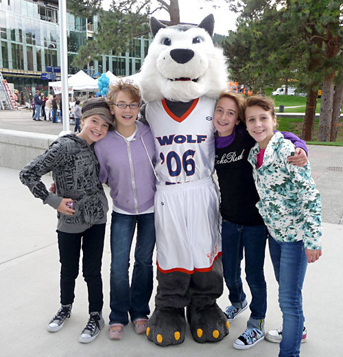 TRU Athletics mascot Wolfie and Cameron (left, wearing hat), Alana (purple), Jordyn (black & purple), and Emma while attending TRU's 40th anniversary celebration on Sept. 10. The four girls say they are on a mission to find out Wolfie's identity. Despite their efforts, Wolfie isn't offering clues and neither are his handlers.