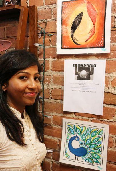 Tanya Thomas poses beside her artwork, currently for sale at The Art We Are in Kamloops. Proceeds go towards The Borgen Project.