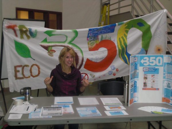 University student in front of table advertising ECO club. 