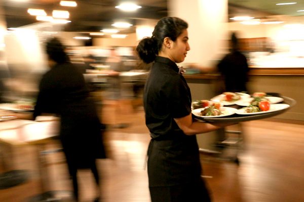 Gala servers make their way with a plate of food from the Den to the Grand Hall
