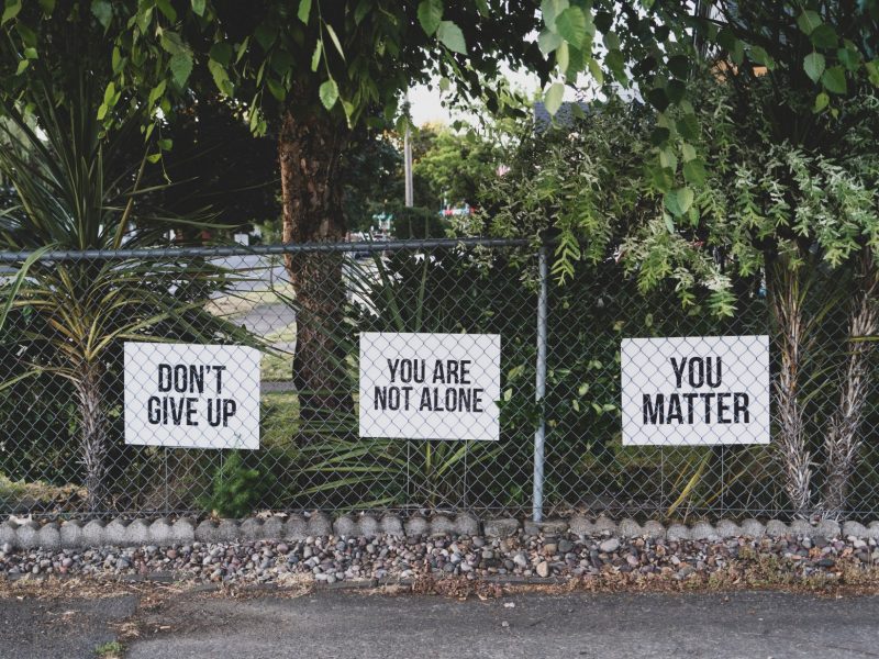铁链栅栏上的标语写着:不要放弃，你并不孤单，你很重要