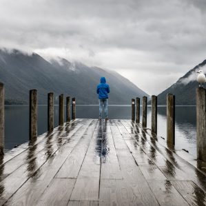 person standing on the edge of a dock on a cloudy day