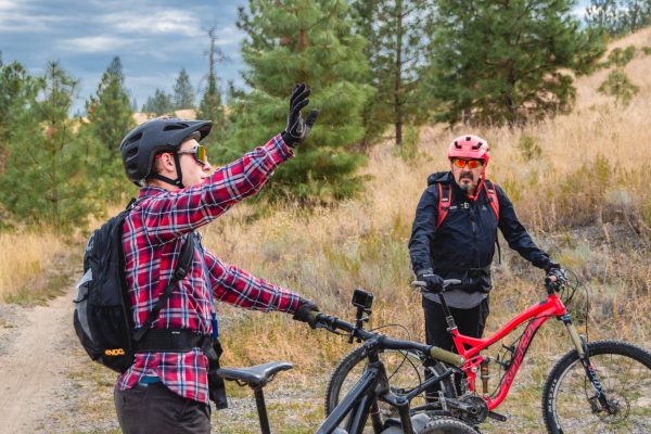 Two people have a conversation along mountain biking trails