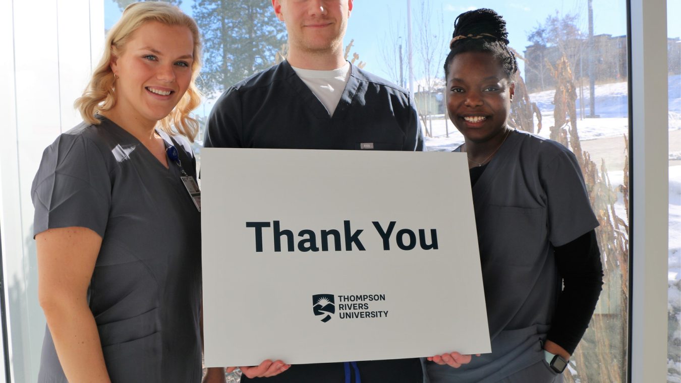 Students hold a thank-you sign.