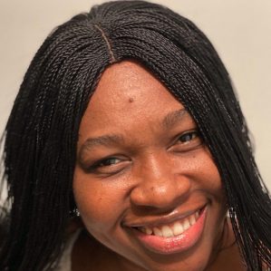 close up image of a smiling woman with braids.