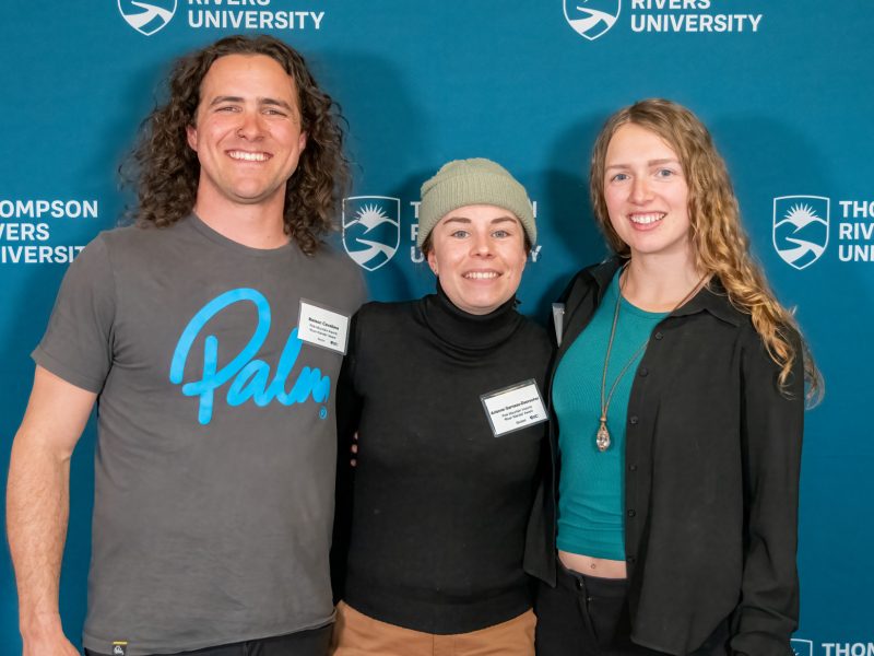 Three smiling people pose for a photo