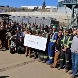 A large group of people gather for a cheque presentation from local business representatives.