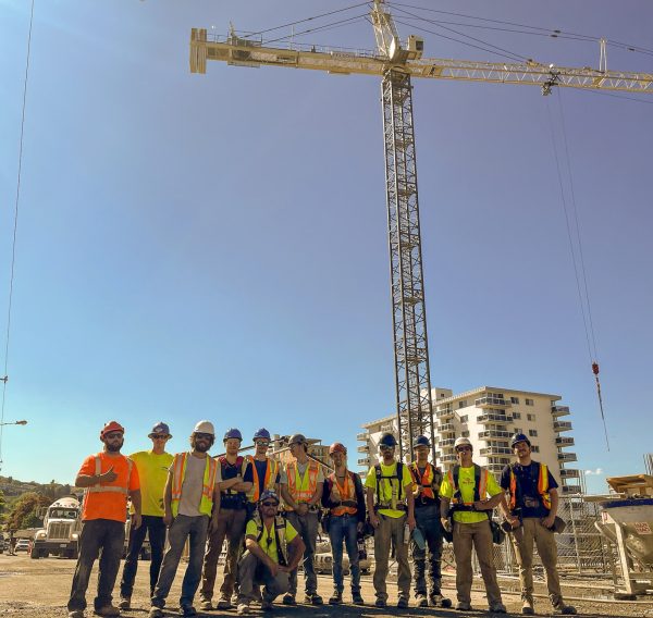 Carpentry students in front of giant crane.