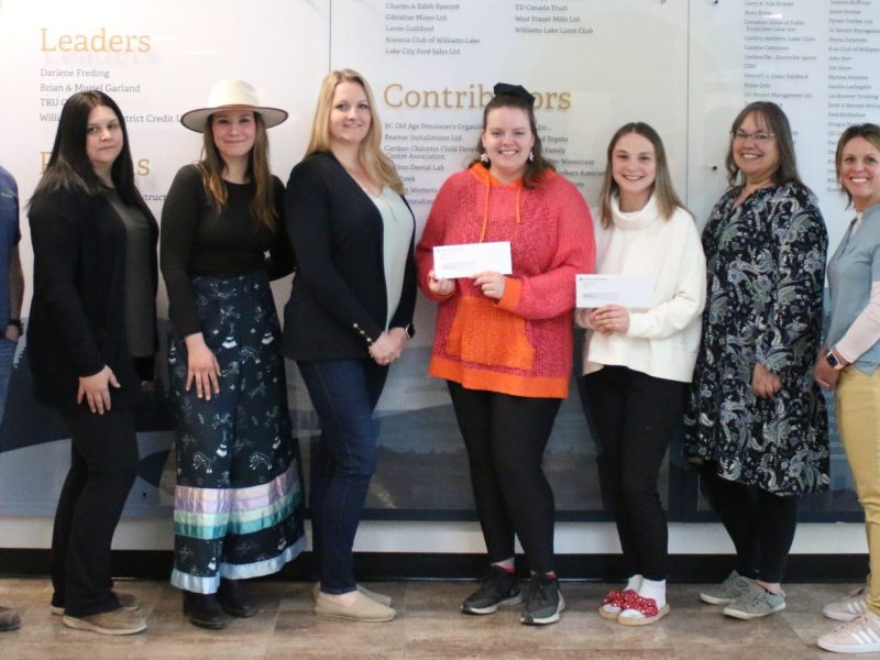 A group of students, instructors and donors stand together following an award ceremony.